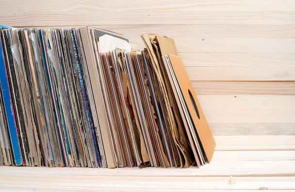 Bild im Retro-Stil einer Sammlung alter Schallplatten mit Hüllen auf Holzgrund. Kopierraum - Foto, Bild