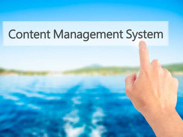 Content Management System - Handdrücken auf Knopfdruck bei verschwommenem Ba - Foto, Bild