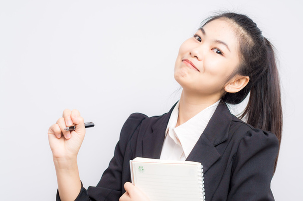 Portrait de heureux asiatique souriant femme d'affaires avec livret porter
 - Photo, image