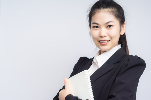 Азиатская улыбающаяся молодая деловая женщина с книгой
 - Фото, изображение