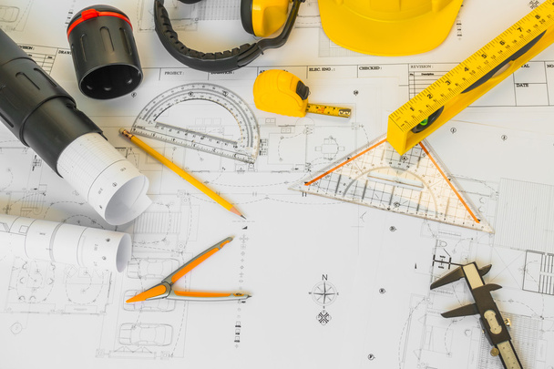 Planos de construção com capacete amarelo e ferramentas de desenho em bluep
 - Foto, Imagem