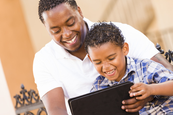 Padre e hijo de raza mixta usando tableta de computadora Touch Pad
 - Foto, imagen