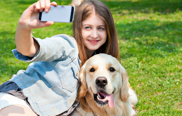 Girl and her dog selfie summer on a background of green grass. - Fotografie, Obrázek