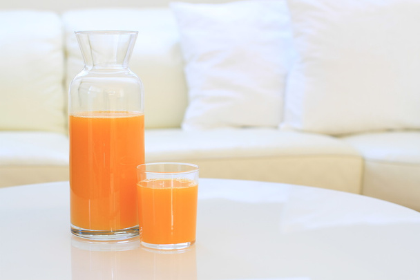 Vetro di succo d'arancia su un tavolo in un soggiorno
 - Foto, immagini