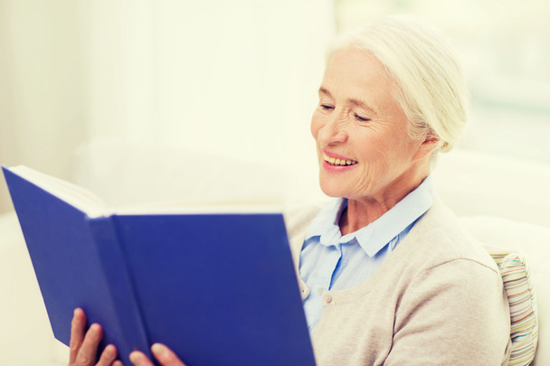 happy smiling senior woman reading book at home - Foto, Imagen