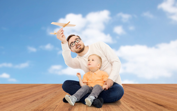 vader en zoontje spelen met speelgoed vliegtuig - Foto, afbeelding