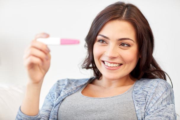 happy woman looking at home pregnancy test - Fotografie, Obrázek