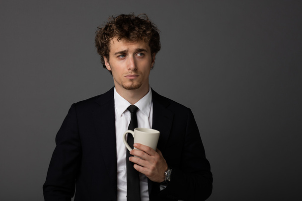 elegant man in suit with a cup on gray background - Foto, immagini