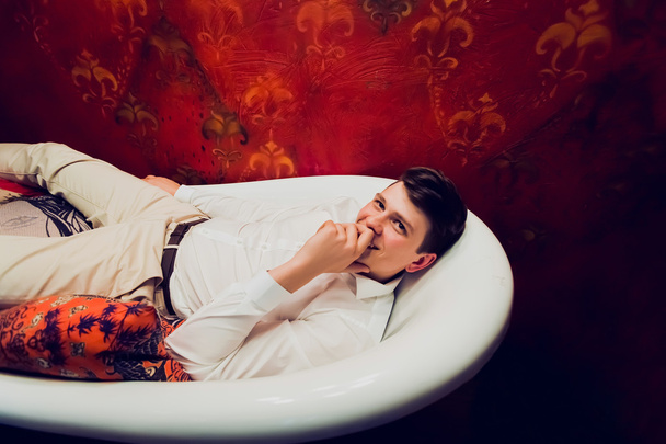 Nuori mies makaa vaatteet kylpyhuoneessa
 - Valokuva, kuva