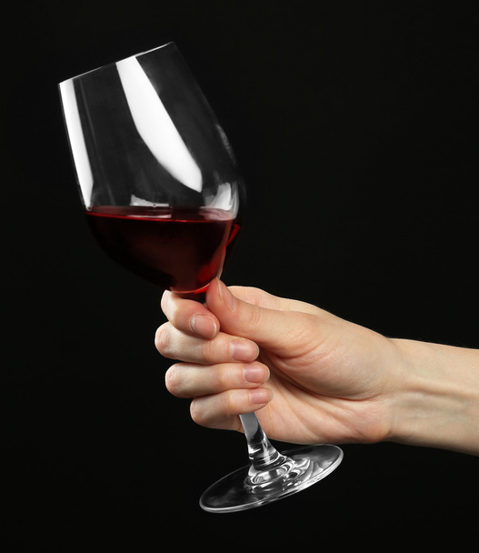 Female hand holding glass of red wine  - Foto, Imagen