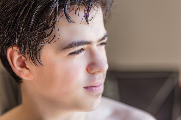 Nahaufnahme des Gesichts eines jungen Teenagers im Profil in Innenräumen unter grellem Sonnenlicht - Foto, Bild