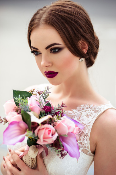 gorgeous bride with fashion makeup and hairstyle in a luxury wedding dress - Foto, imagen