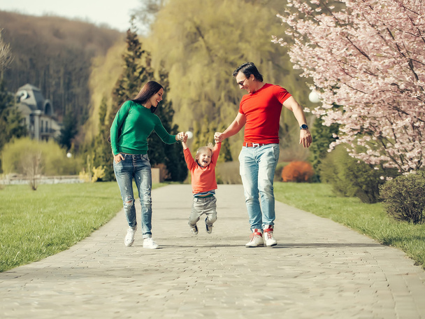 Happy family in blooming park - Фото, изображение