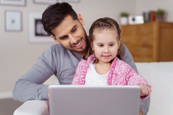 Little girl on her Dads lap looking at a tablet - Foto, Imagen