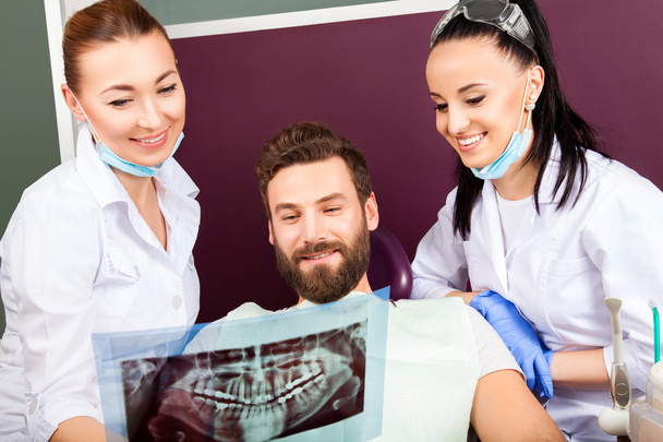 El dentista muestra una radiografía de dientes del paciente
. - Foto, Imagen