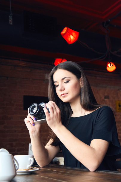 Young girl photographer with old analog camera in cafe - Фото, зображення