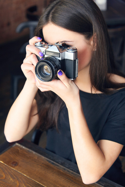 Mladá dívka fotograf s staré analogové kamery v kavárně - Fotografie, Obrázek