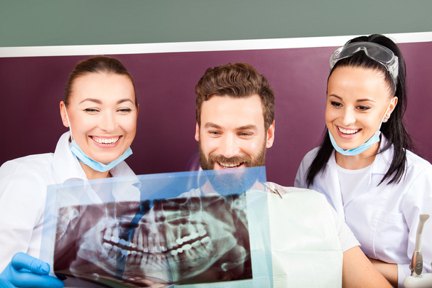Femme médecin et son assistante souriante montrant les dents radiographie
 - Photo, image