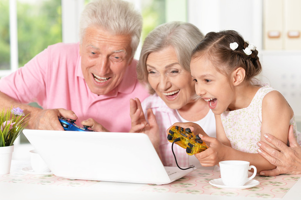 grandparents  and  little girl using laptop - Фото, изображение