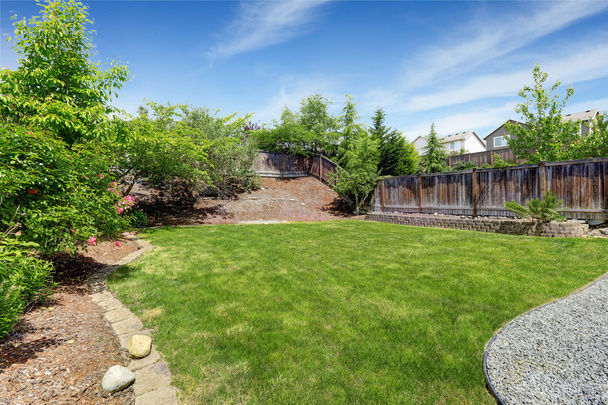 Spacious backyard area with dark brown wooden fence - Photo, Image