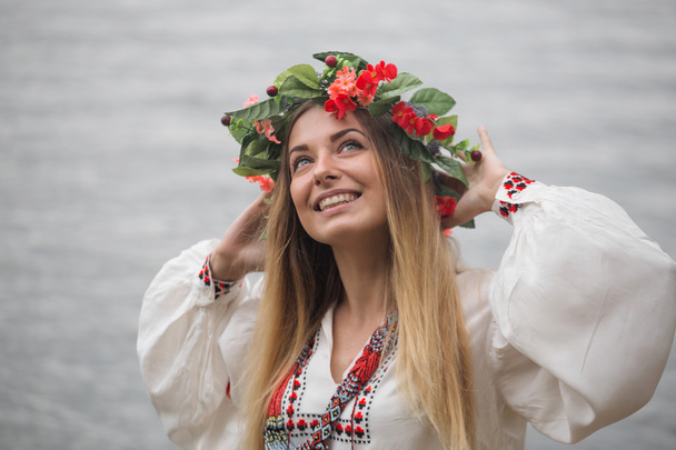 Giovane donna felice indossa chiusure tradizionali e ghirlanda
 - Foto, immagini