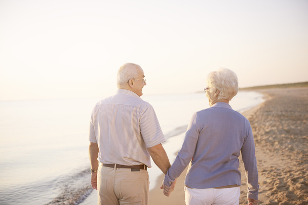Seniorenpaar geht am Strand spazieren - Foto, Bild