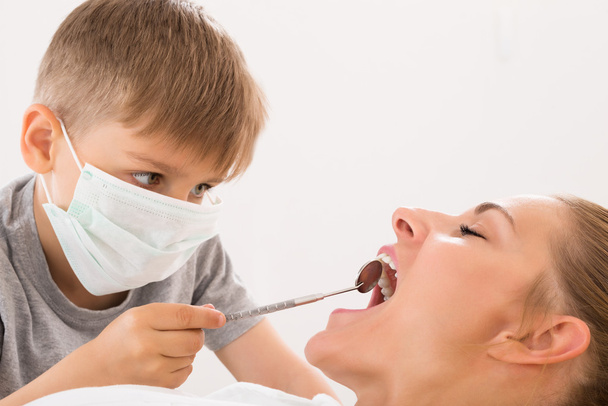 Boy Examining Teeth Of Woman - Foto, immagini