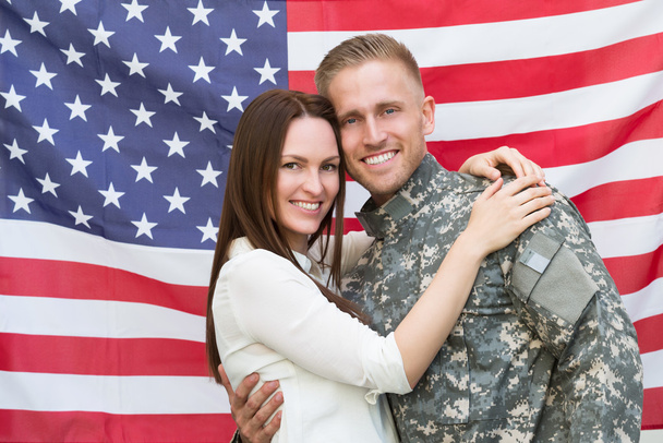 Male Soldier With His Wife In Front Of American Flag - Фото, зображення