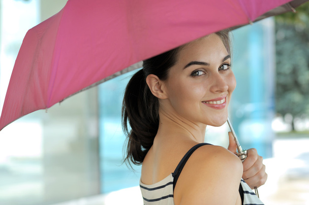 Woman goes under an umbrella - Valokuva, kuva