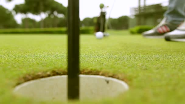 Golfspieler schlägt Ball auf Golfplatz - Filmmaterial, Video