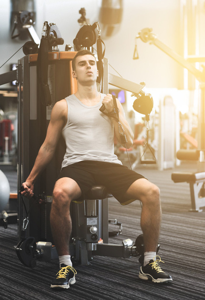 man exercising on gym machine - Foto, afbeelding