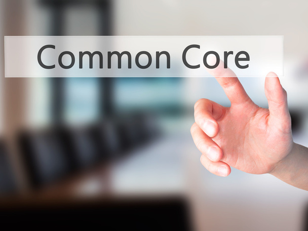 Common Core - Hand pressing a button on blurred background conce - Photo, Image