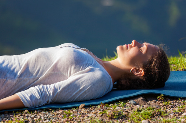Femme se détend dans le yoga asana Savasana en plein air
 - Photo, image