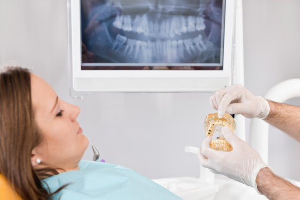 Paciente feminina com modelo de mandíbula dentária
  - Foto, Imagem