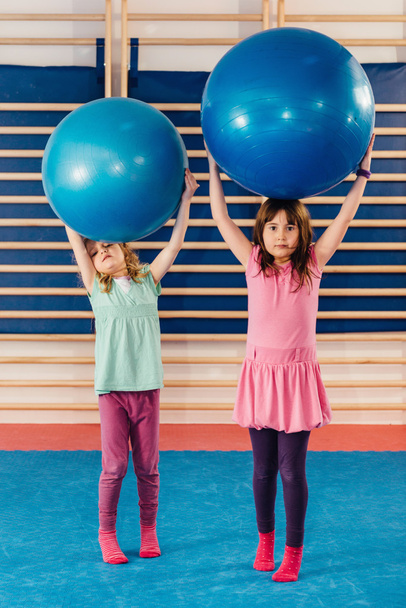 Kleine meisjes spelen met fitness ballen - Foto, afbeelding