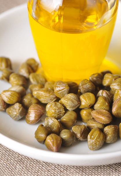 kapary a olivový olej na desce - Fotografie, Obrázek