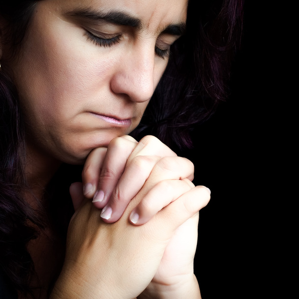 Hispanic woman praying isolated on black - Фото, зображення