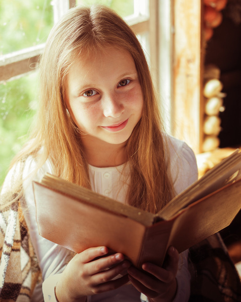 Village girl with a book by the window. - Fotoğraf, Görsel