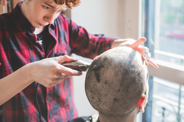 Žena stříhat vlasy člověka pomocí razor  - Fotografie, Obrázek