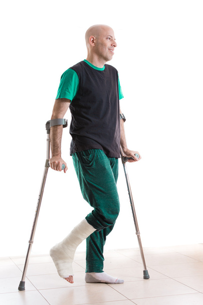 Νεαρός άνδρας με ένα πόδι χυτό και δεκανίκια - Φωτογραφία, εικόνα