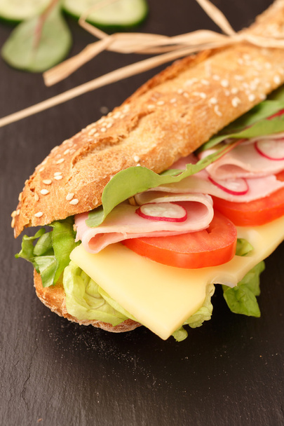 サンドイッチ フランスパン、チーズ、ハム、トマト、大根、レタスのクローズ アップ。手作りの料理。ぱりっとしたパン - 写真・画像