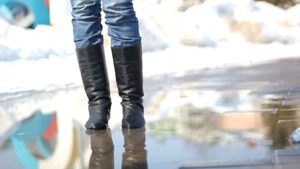 Young woman in rain boots jumping on a puddle - Footage, Video
