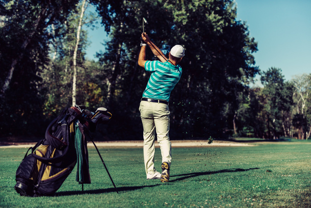 Golfer swingen op het ophangen van gras - Foto, afbeelding