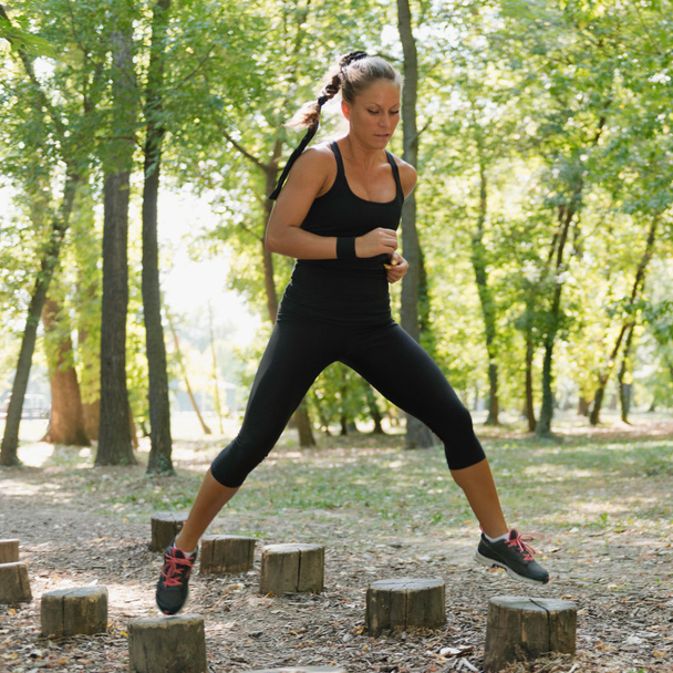 Жінка-спортсменка біжить на перешкодній трасі
 - Фото, зображення