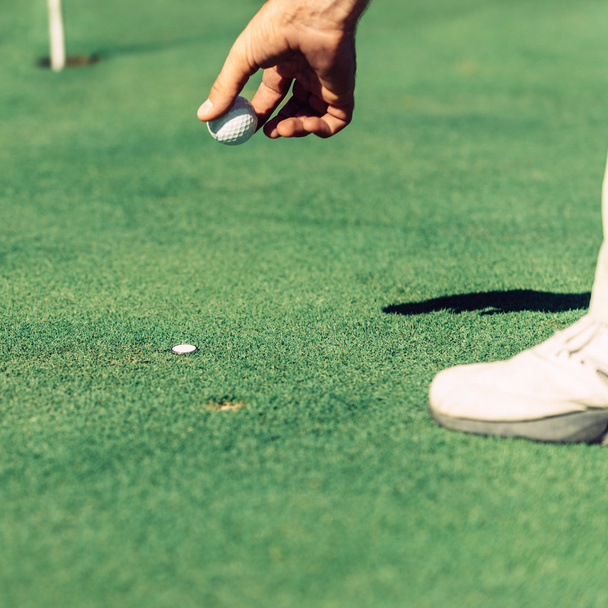 Golfeur plaçant marqueur
  - Photo, image