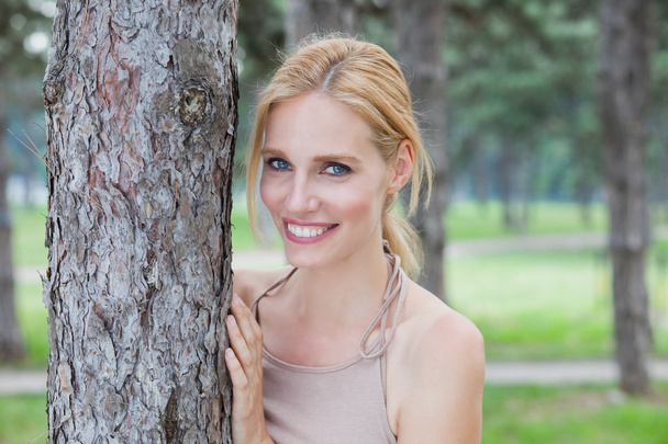 Beautiful blonde with blue eyes enjoying a walk in the forest - Φωτογραφία, εικόνα