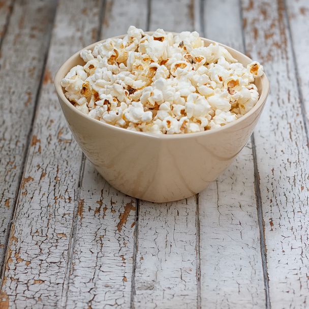 Fresh popcorn in bowl on white wooden table - Photo, Image