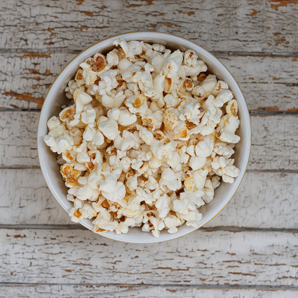 bowl of popcorn on a light background - Φωτογραφία, εικόνα