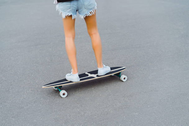 young woman posing in street with skateboard - Photo, Image