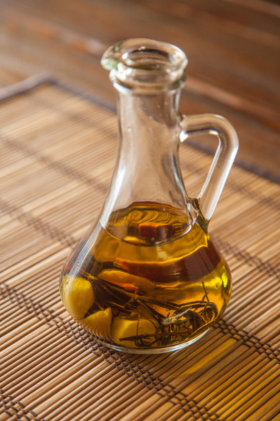 karaf met olijfolie op tafel - Foto, afbeelding
